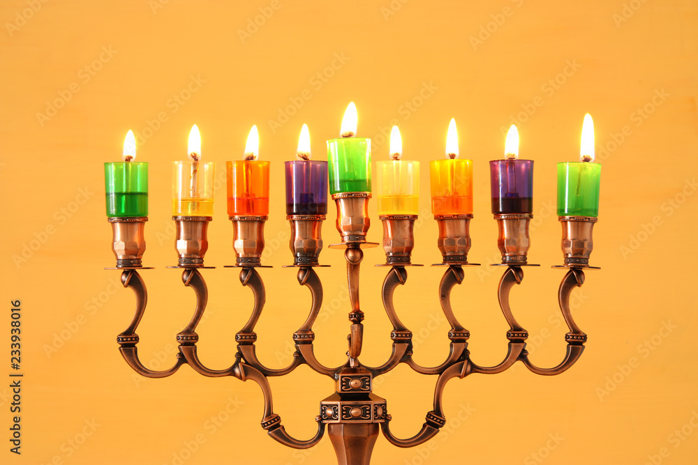 image of jewish holiday Hanukkah background with menorah (traditional candelabra) and colorful oil candles. image of jewish holiday Hanukkah background with menorah (traditional candelabra) and colorful oil candles.