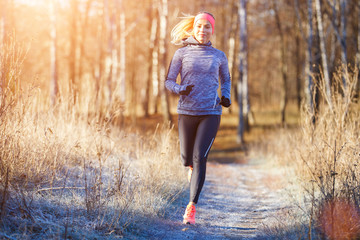 Young girl running in the park in early winter
