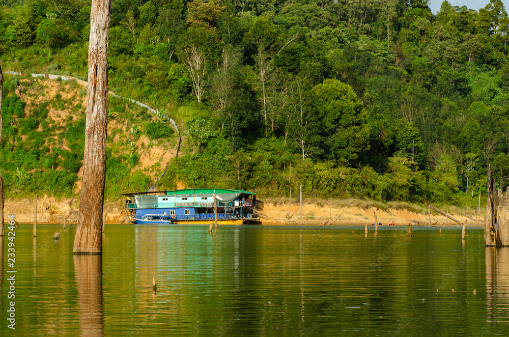 Naklejka premium Houseboat moored near the lakeshore under bright sunny day over beautiful nature background