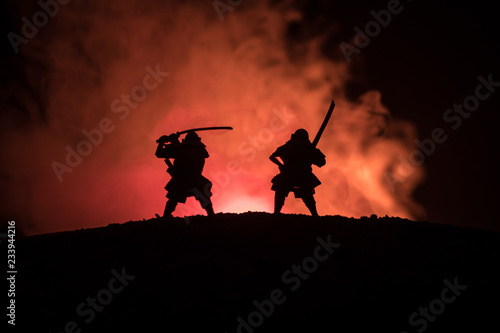 Silhouette of two samurais in duel. Picture with two samurais and sunset sky