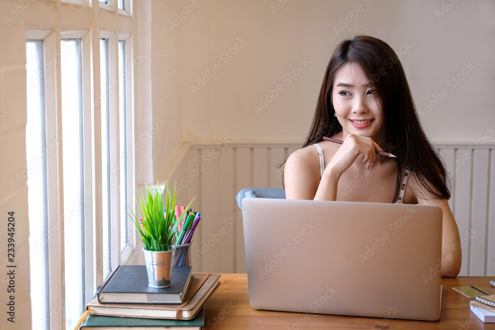 Beautiful Young woman working on laptop and computer at home Beautiful Young woman working on laptop and computer at home