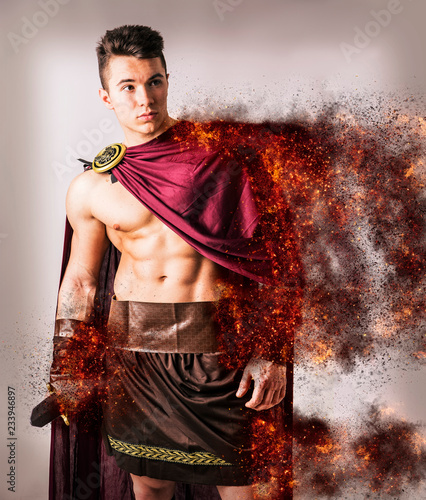 Young handsome shirtless man with muscular body wearing outfit of ancient warrior with burning sparkles effect