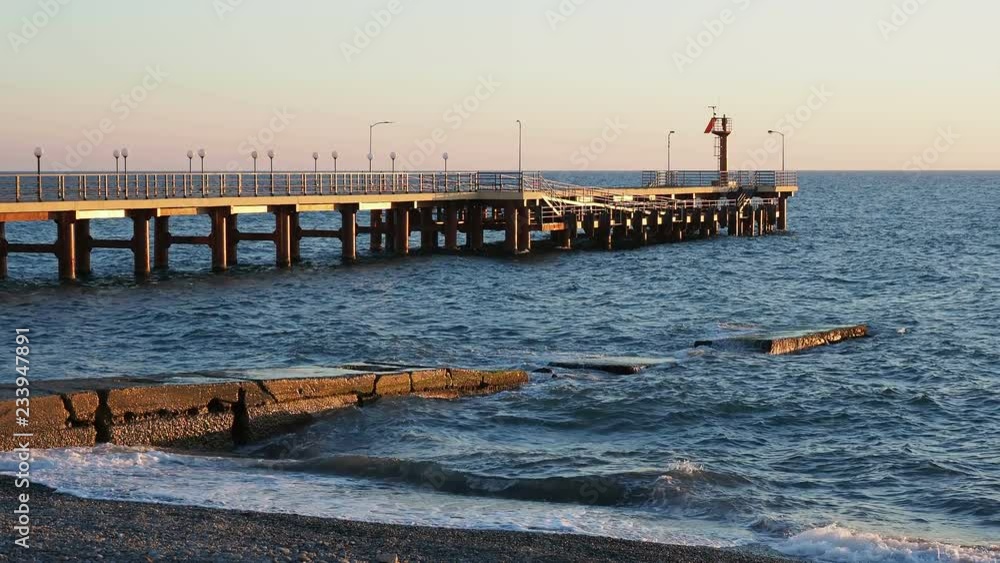 Pier with the lighthouse. Sunset on Black sea, Adler, Russia. Pier with the lighthouse. Sunset on Black sea, Adler, Russia.