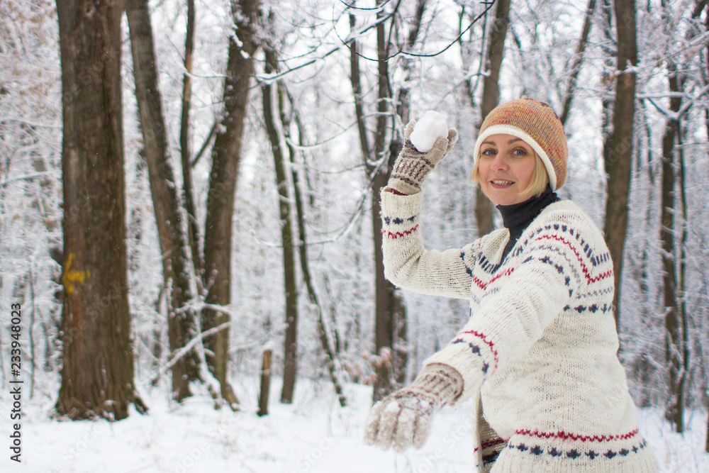 Girl throwing a snowball. Games in the winter forest. Fun in the open air. Happy woman. Christmas mood. Winter vacation in the ski resort. Sculpt lumps of snow. Man in the winter forest. Women's smile Girl throwing a snowball. Games in the winter forest. Fun in the open air. Happy woman. Christmas mood. Winter vacation in the ski resort. Sculpt lumps of snow. Man in the winter forest. Women's smile