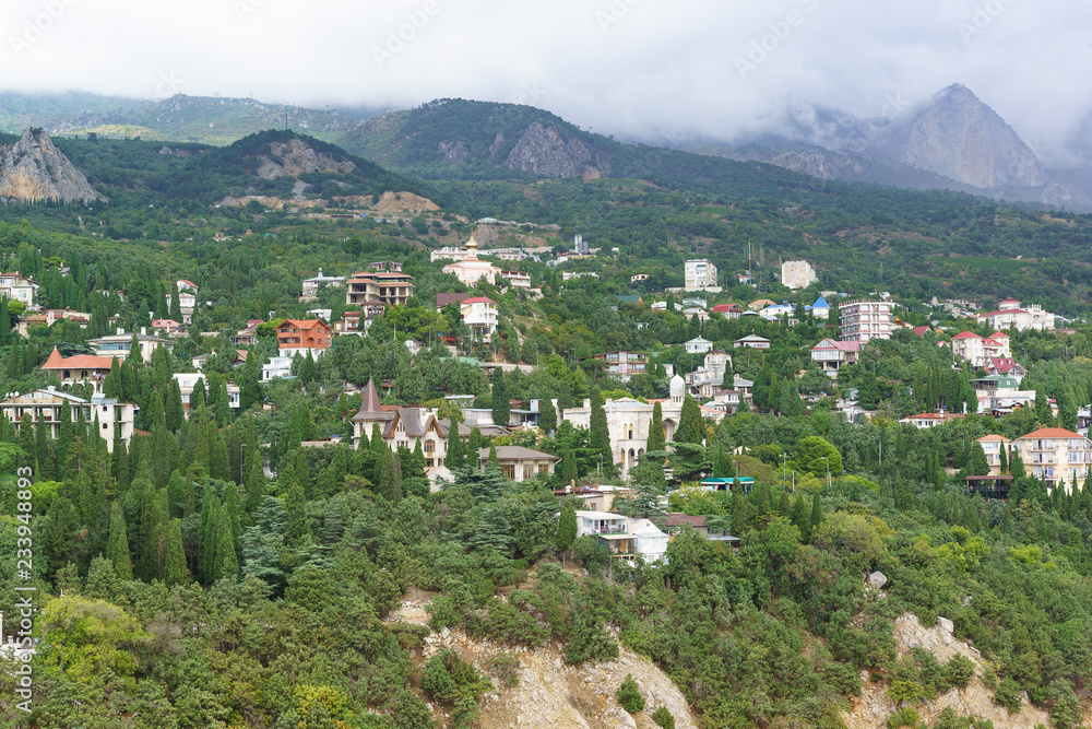 A large black cloud is coming from the mountains to the low-rise resort village Simeiz