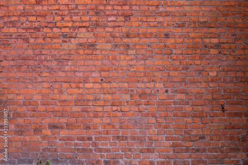 A fragment of a red brick wall at an idle factory shot in late autumn