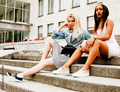 Two teenage girls infront of university building smiling  having