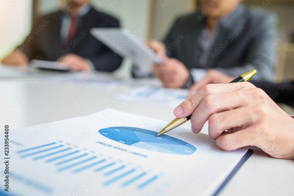 Business people discussion and summary financial information at meeting Business people discussion and summary financial information at meeting
