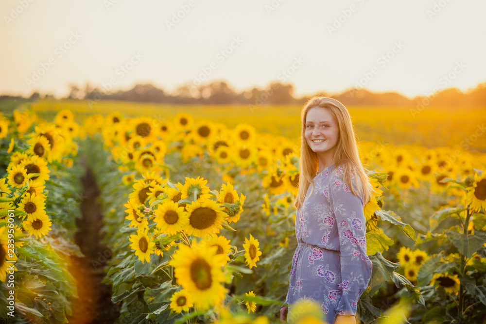 woman in a sunflower field at sunset woman in a sunflower field at sunset