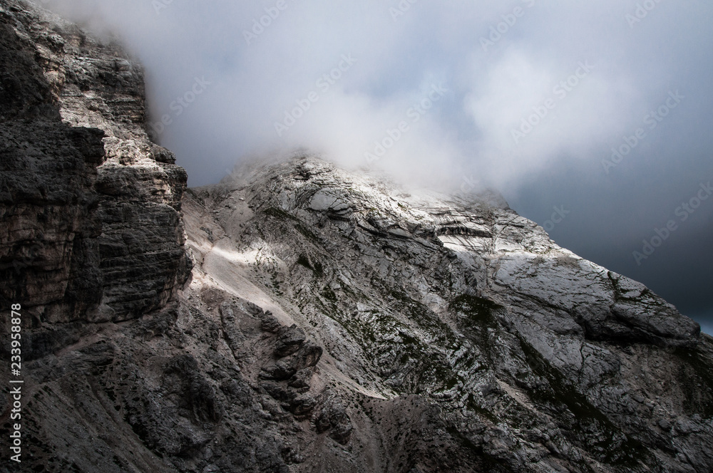 suggestive natural background of sun light rays on rock mountain wall in cloudy sky suggestive natural background of sun light rays on rock mountain wall in cloudy sky
