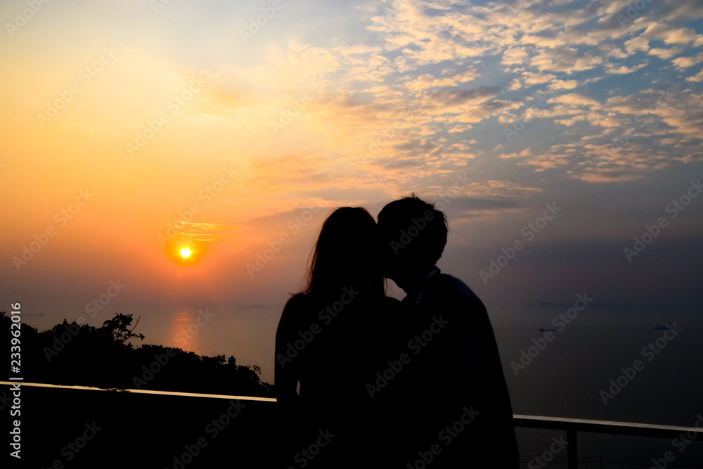 Silhouette couple on the view point to watch sunset