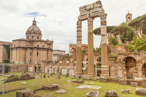 Ruins of the Temple of Venus Genetrix in Forum Romanum. Rome, Italy. Focused from a public street. Horizontally. The church of Santi Luca e Martina is in the background.  photo