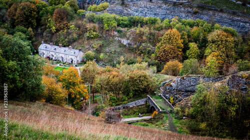 Old stone cottages in the bottom of a dale surrounded by autumn trees on a cloudy day. Taken in the Derbyshire Dales. 