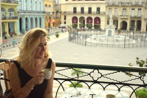 woman sitting on terrace and drinking Cuban coffee © keremberk