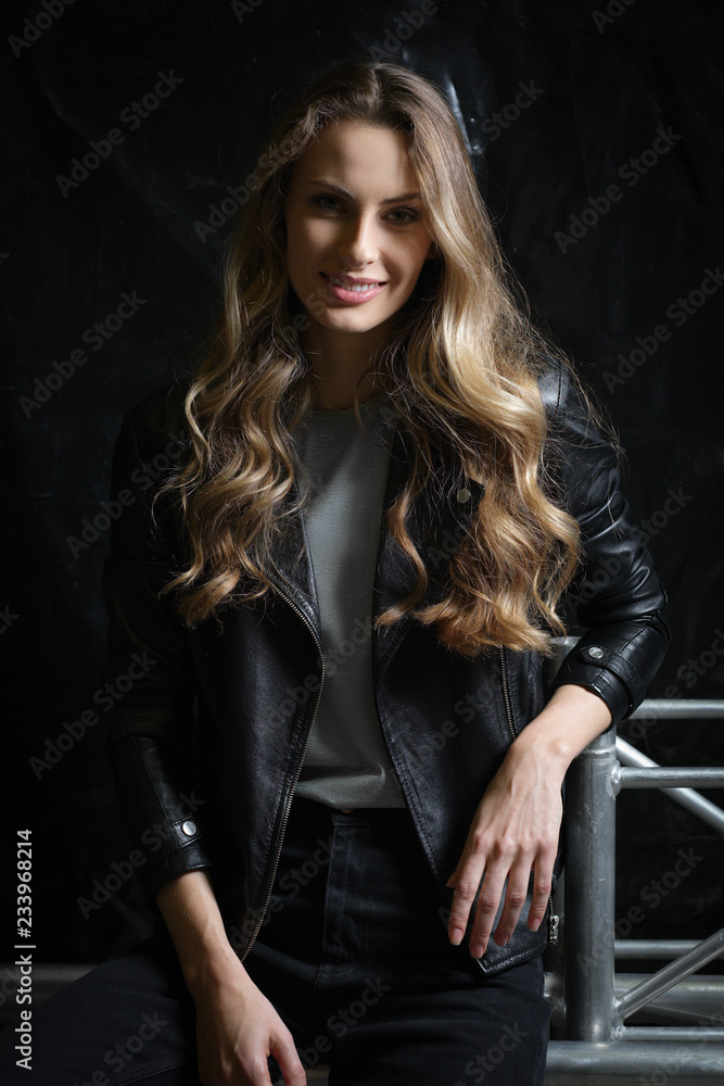 Beautiful girl with long curly hair in black leather jacket, t-shirt and jeans Beautiful girl with long curly hair in black leather jacket, t-shirt and jeans
