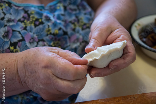 Senior lady making dumplings with stuffing
