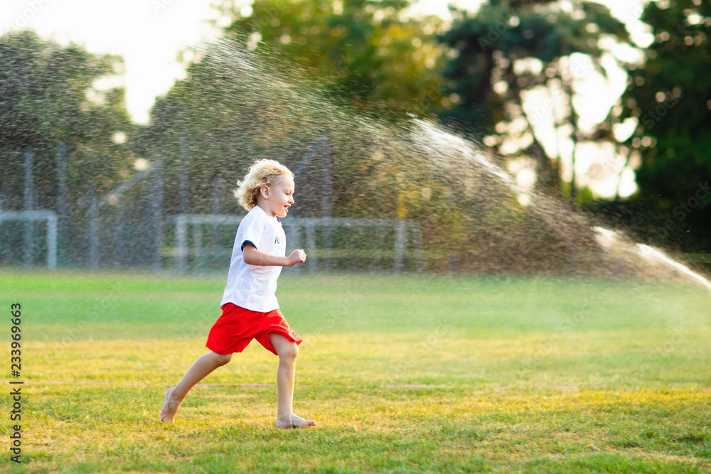 Kids play with water. Child with garden sprinkler.
