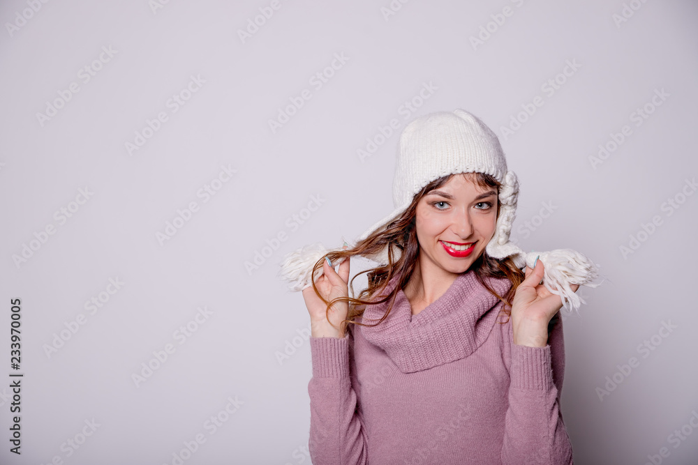 Woman wearing warm winter clothes with kniteed hat. Smiling girl isolated on white background.beautiful woman in winter hat.Autumn warm.Woman smiling and look at the camera, joyful cheerful mood. Woman wearing warm winter clothes with kniteed hat. Smiling girl isolated on white background.beautiful woman in winter hat.Autumn warm.Woman smiling and look at the camera, joyful cheerful mood.