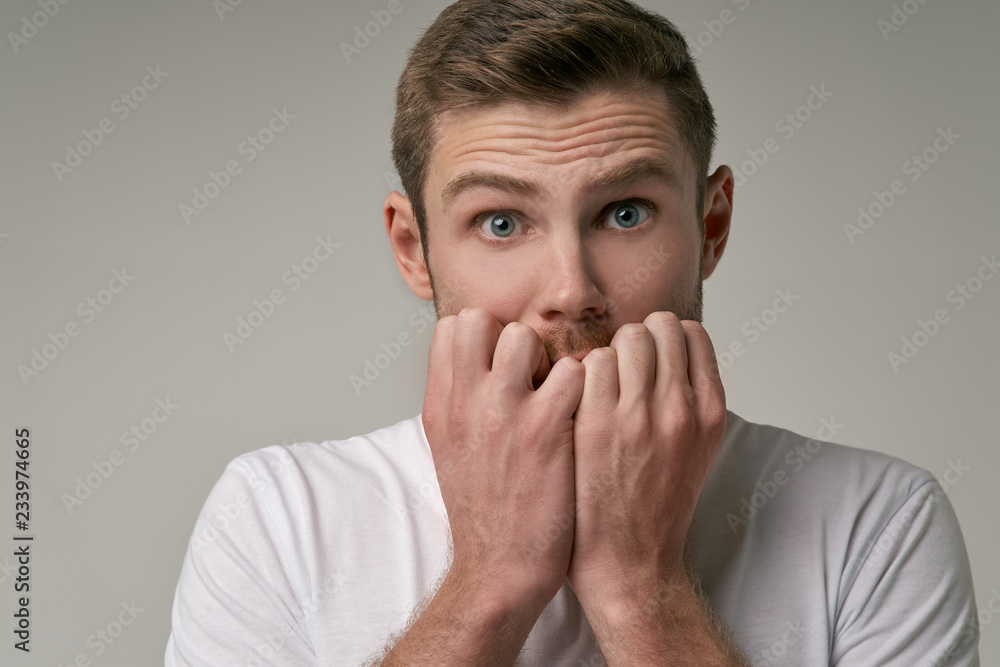 A frightened bearded man looks in horror, opens eyes wide, being shocked by high prices in store. astonished guy has a bristle looks with a shocked expression, white background in the Studio A frightened bearded man looks in horror, opens eyes wide, being shocked by high prices in store. astonished guy has a bristle looks with a shocked expression, white background in the Studio