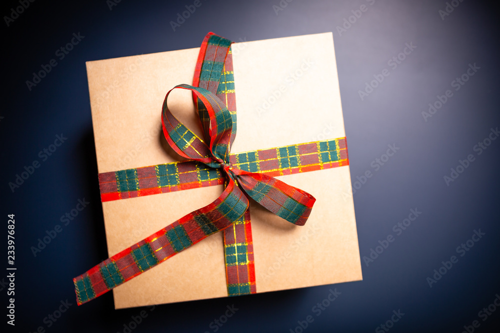 Carton box on blue background decorated with ribbon. Christmas theme. Carton box on blue background decorated with ribbon. Christmas theme.
