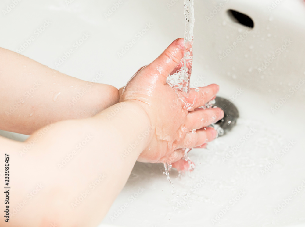 Fototapeta premium Young child washing hands with colorful soap. Hygine concept.