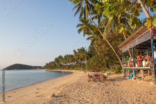 anonymous people sitting in beach bar at tropical coast