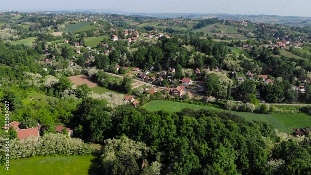 Aerial drone shot over the east european mountain village surrounded with forest. Lush green trees during Summer. Shot in 4K (UHD). Aerial drone shot over the east european mountain village surrounded with forest. Lush green trees during Summer. Shot in 4K (UHD).