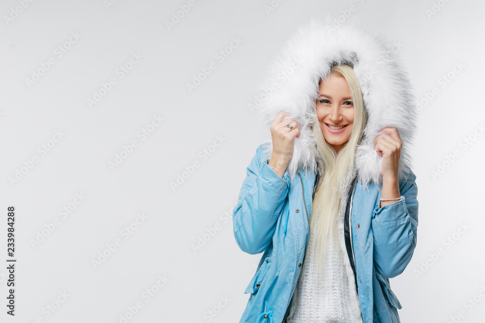 Fashion portrait of young beautiful blond woman with fur. white fur hood. winter style. Copy space for text on left side Fashion portrait of young beautiful blond woman with fur. white fur hood. winter style. Copy space for text on left side