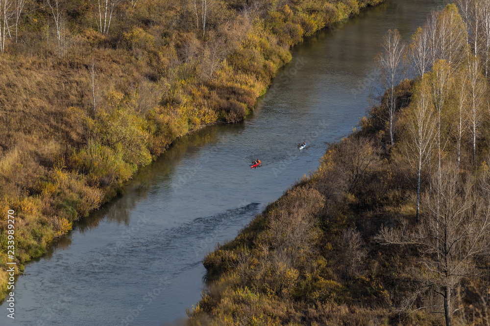 Kayaking on the Siberian river. The change of seasons in Russia. Yellow forest on the banks of the cold river. Kayaking on the Siberian river. The change of seasons in Russia. Yellow forest on the banks of the cold river.