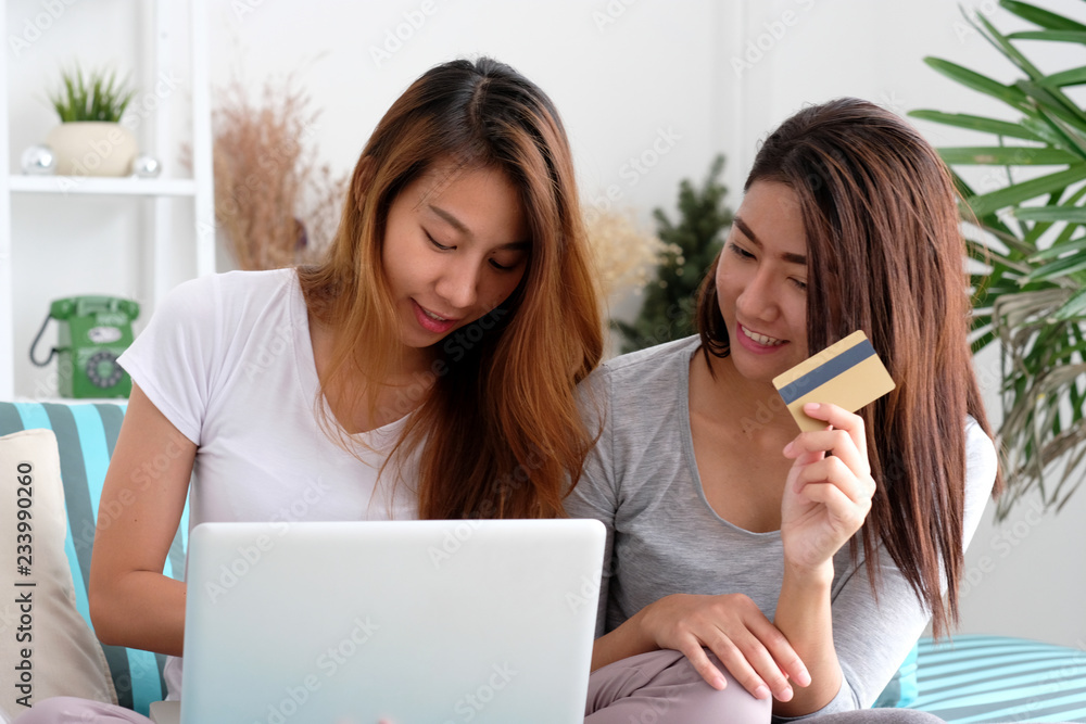 Εκτύπωση καμβά Two young asian women holding credit card and using laptop computer for shoppin
