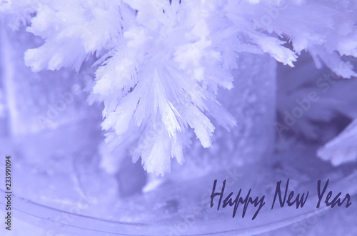 Beautiful crystal or snowflake. Christmas or New Year  greeting cards  background. The inscription in English  Happy New Year.  Selective focus  blur  macro  macro.