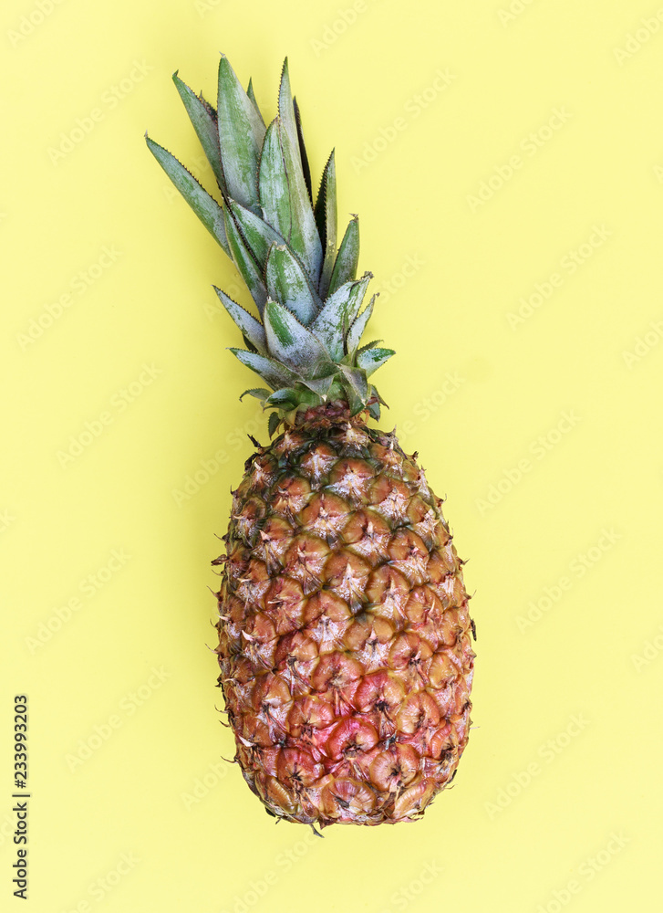 Pineapple, delicious exotic tropical fruit. Yellow background.