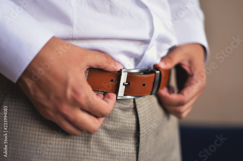 man adjust his belt of elegant suit. getting ready concept.