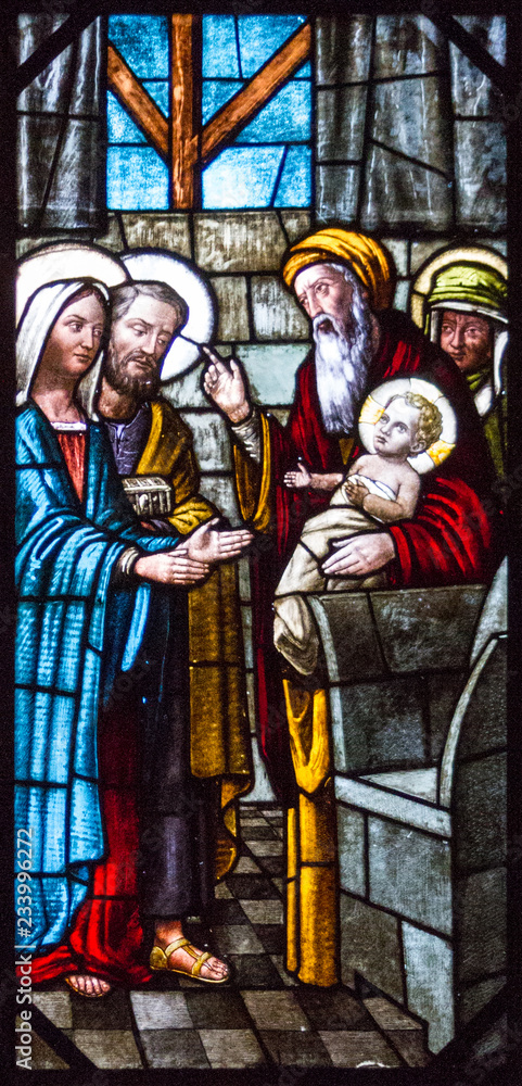 Obraz premium Casorate Primo, Italy. 2017/12/8. A stained glass window depicting Feast of the Presentation of Our Lord Jesus and the the Purification of the Blessed Virgin Mary in the church of San Vittore Martire.