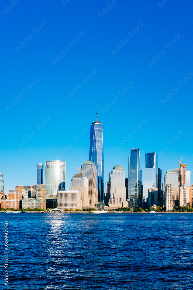 Skyline of downtown Manhattan over Hudson River under blue sky, at sunset, in New York City, USA