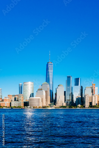 Skyline of downtown Manhattan over Hudson River under blue sky  at sunset  in New York City  USA