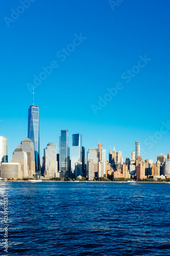 Skyline of downtown Manhattan over Hudson River under blue sky  at sunset  in New York City  USA