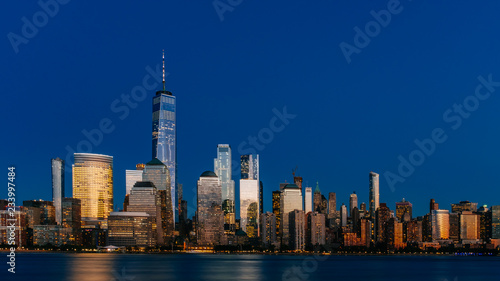 Night view of skyline of downtown Manhattan over Hudson River under dark blue sky, in New York City, USA © Mark Zhu