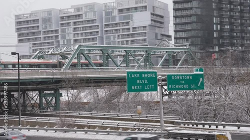 Queen Street Viaduct crossing the Don River and DVP in Toronto. Streetcar passing with snow falling. Winter. Handheld shot with stabilized camera.  photo