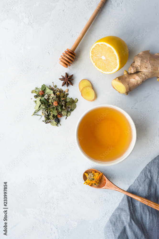 Herbal tea and lemon, ginger, honey on concrete background with copy space. Top view. Vertical photo. Herbal tea and lemon, ginger, honey on concrete background with copy space. Top view. Vertical photo.