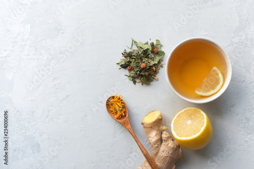 Herbal tea for colds and flu. Lemon, ginger and herbs on concrete background with copy space. Top view. 