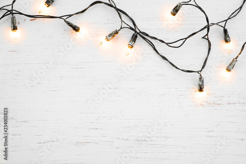 Christmas lights bulb decoration on white wood. Merry Christmas and New Year holiday background. top view