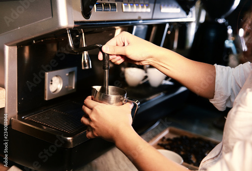 Barista preparing milk for takeaway coffee. Close-up