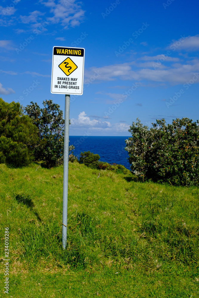 Australian warning sign, snakes may be present in long grass, NSW coast, Australia