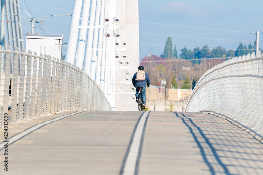 Bicyclist riding on the empty bridge in the middle of the day. Bicyclist riding on the empty bridge in the middle of the day.