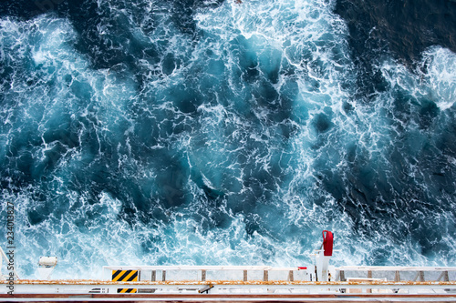 Lifeboat launching appliance from upper view on cruise ship with splashing waves in background