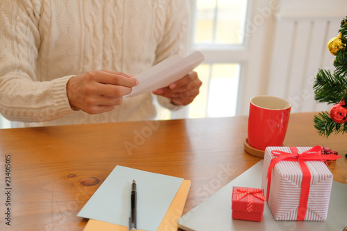 man opening sending christmas letter greeting card holiday wishes with xmas decoration