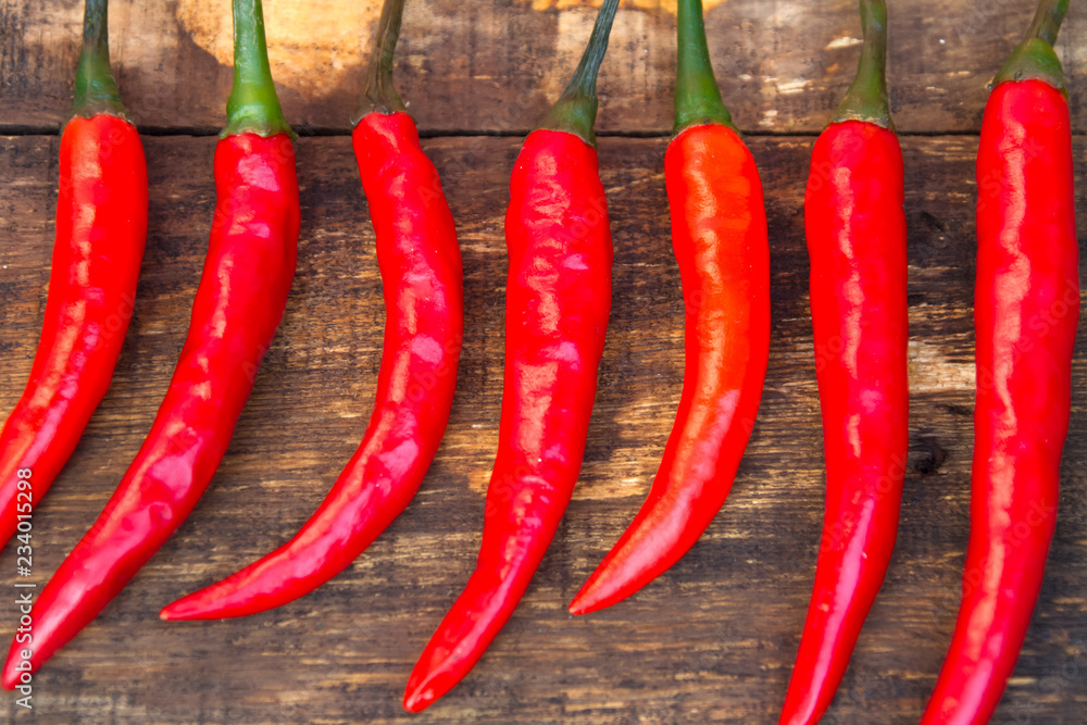 chili pepper on wooden background, top view