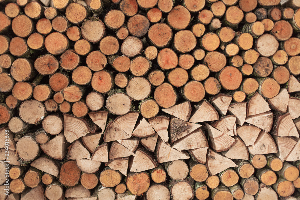 A woodpile of round logs and wood chucks in the countryside. A woodpile of round logs and wood chucks in the countryside.