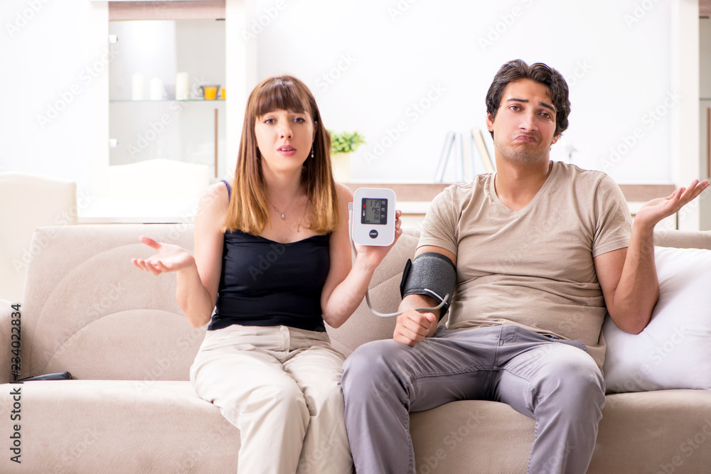 Wife checking husband's blood pressure Wife checking husband's blood pressure